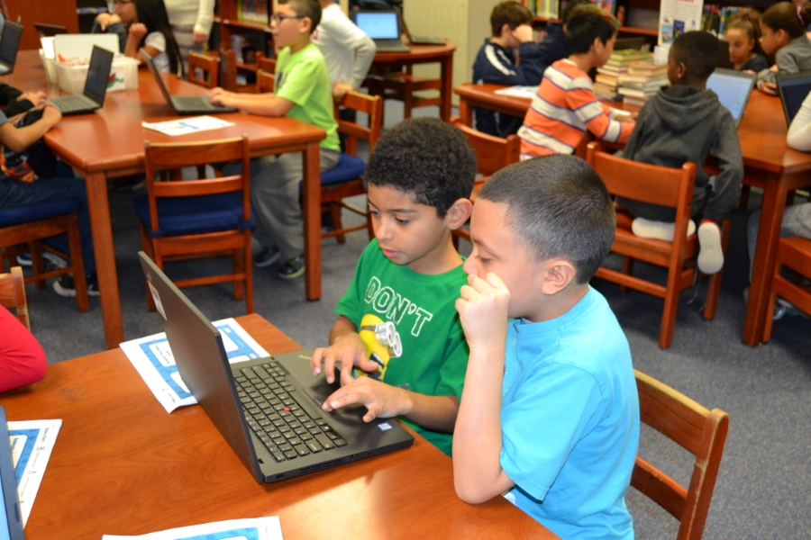 two boys with a laptop in the library two boys with a laptop in the library